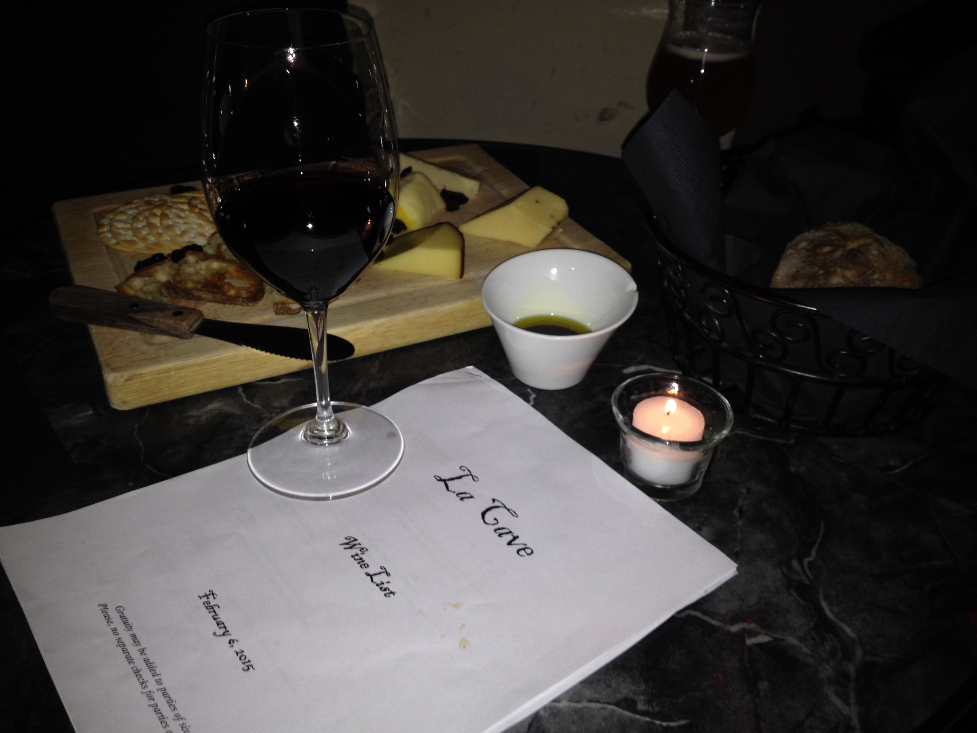 Figure. La Cave Du Vin. A nice glass of wine with a side cheese board, eaten in the dark. 